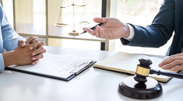 A legal professional handing over a Share Purchase Agreements document to a client, with a gavel and scales of justice on the table.