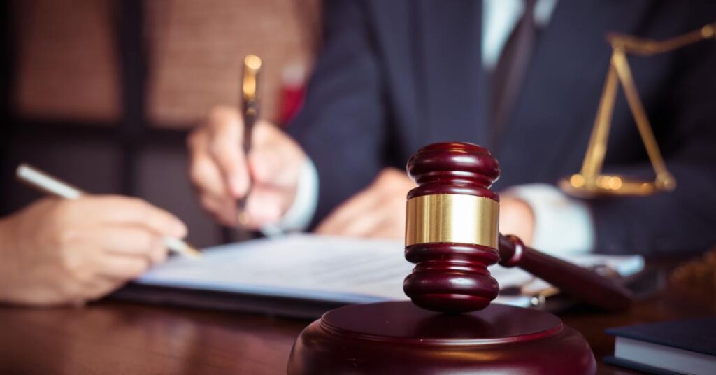 Close-up of a lawyer guiding a client through legal paperwork with a gavel in focus, representing how to prepare a franchise disclosure in Toronto.