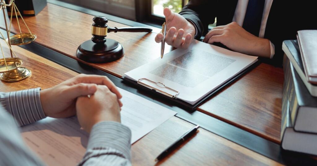 Lawyer discussing legal documents with a client in a law office, symbolizing top questions to ask when hiring a franchise lawyer in Ontario.