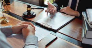 Lawyer discussing legal documents with a client in a law office, symbolizing top questions to ask when hiring a franchise lawyer in Ontario.