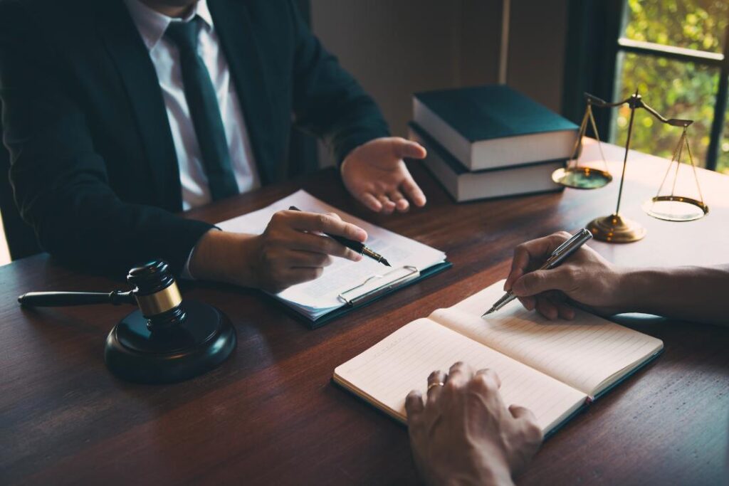 Lawyer discussing legal strategy with client while reviewing documents about how to resolve franchise disputes in Ontario