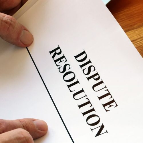Image of hands holding a document with "DISPUTE".