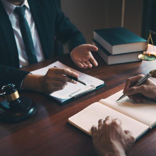 Lawyer discussing legal strategy with client while reviewing documents about how to resolve franchise disputes in Ontario