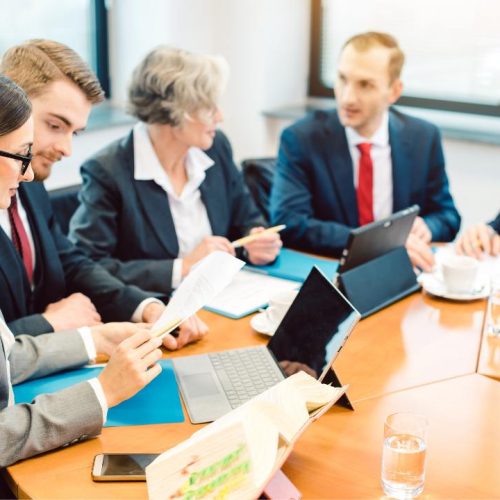 Business team in meeting discussing documents and strategies related to the different types of franchise agreements in Canada.