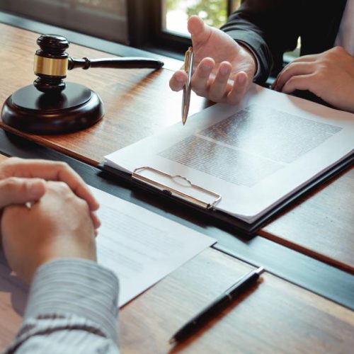 Lawyer discussing legal documents with a client in a law office, symbolizing top questions to ask when hiring a franchise lawyer in Ontario.