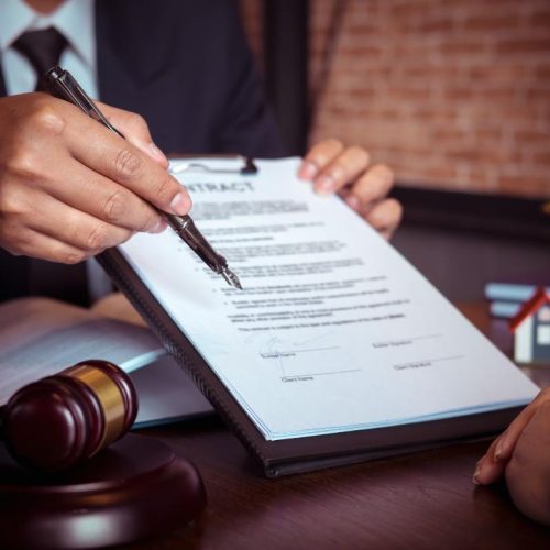 Lawyer explaining contract terms to client while reviewing legal documents related to choosing the best legal structure for a franchise.